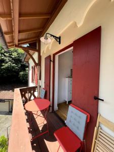 a balcony with a red door and a table and chairs at Apartment Siggi 81 sqm Balcony and Mountain View in Siegsdorf