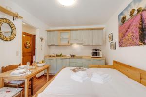 une cuisine avec une table à manger et une table et une cuisine avec un plan de travail dans l'établissement Hermitage Studio - close to ski pistes - Happy Rentals, à Borgata Sestriere