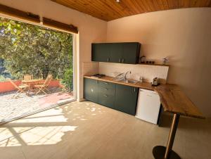 a kitchen with green cabinets and a large window at Quinta dos Sarilhos in Pedrógão Grande