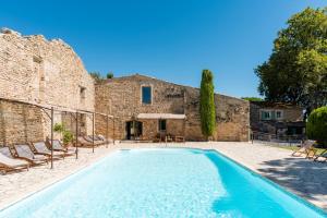 a swimming pool in front of a building with a house at La Mouline sublime domaine privatif avec piscine à Pézenas in Pézenas