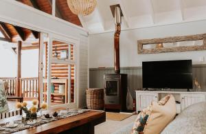 a person sitting on a couch in a living room with a tv at Forest Hideaway In Knysnas Phantom Pass in Knysna