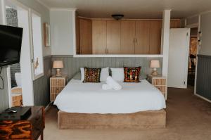 a bedroom with a large white bed with two lamps at Forest Hideaway In Knysnas Phantom Pass in Knysna