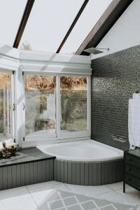 a bathroom with a large window and a bath tub at Forest Hideaway In Knysnas Phantom Pass in Knysna