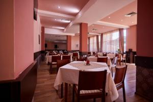 a restaurant with tables and chairs in a room at Хотел "Божур" in Mineralni Bani
