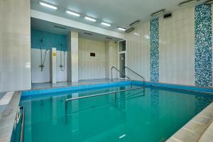 a swimming pool with blue water in a building at Хотел "Божур" in Mineralni Bani