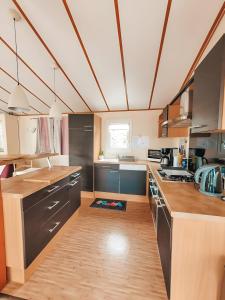 una cucina con pavimenti in legno ed elettrodomestici in acciaio inossidabile di Chalet Du Bonheur Lac De Guerledan a Caurel