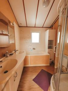 bagno con 2 lavandini e vasca di Chalet Du Bonheur Lac De Guerledan a Caurel