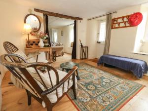 a living room with a chair and a rug at Little Orchard in Thorncombe