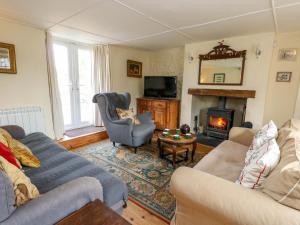 a living room with two couches and a fireplace at Little Orchard in Thorncombe