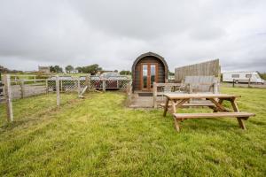 Cabaña de madera con mesa de picnic y banco en Unit 4 - Skiddaw View Camping Pod, en Carlisle