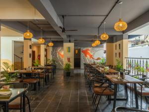 Un restaurante con mesas, sillas y luces. en The Hosteller Bam Goa, Calangute, en Calangute