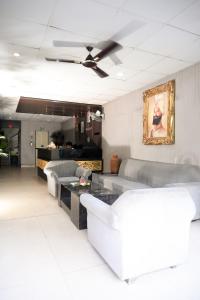 a living room with couches and a ceiling fan at Hotel De Agya Paradise in Ludhiana
