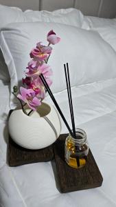 a table with a vase with flowers on a bed at Arabian Desert nights in Bidiyah