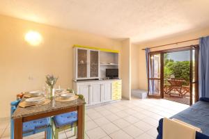 a kitchen and living room with a table with plates on it at Relaxing Baia De Bahas seaview 1Bedroom Apartment B4 sleeps 4 in Marinella +22 photos