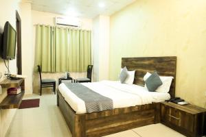 a hotel room with a bed and a television at Hotel De Agya Paradise best hotel at ludhiana railway station in Ludhiana +22 photos