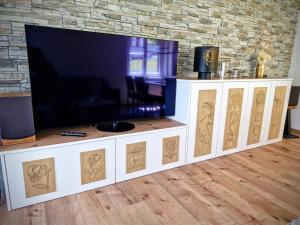 TV de pantalla plana en un centro de entretenimiento blanco en Ferienwohnung Valere B - it's magic gmbh, en Leukerbad