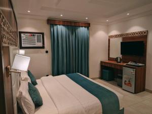 a hotel room with a bed and a television at ليالي - الربوة in Jeddah +1 photo