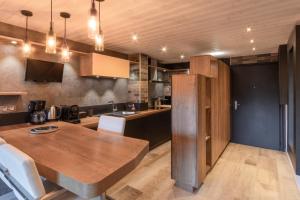 eine Küche mit einem Holztisch in einem Zimmer in der Unterkunft Le Saint Bernard - T2 Terrasse Vue Mont Joli 42m2 in Saint-Gervais-les-Bains