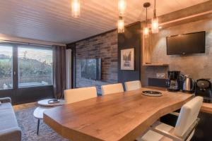 ein Esszimmer mit einem Holztisch und Stühlen in der Unterkunft Le Saint Bernard - T2 Terrasse Vue Mont Joli 42m2 in Saint-Gervais-les-Bains