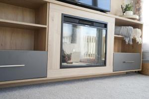 a flat screen tv in a entertainment center at 3-Bed Lodge Sleeps 6 Hot tub in Preston