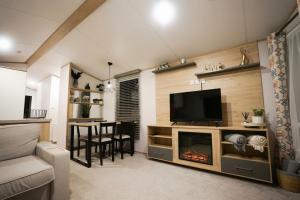 a living room with a tv and a fireplace at 3-Bed Lodge Sleeps 6 Hot tub in Preston
