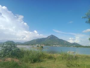 Blick auf einen See mit Bergen im Hintergrund in der Unterkunft Sai Arunachala Farmstay in Tiruvannāmalai