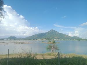 ein großer Wasserkörper mit einem Berg im Hintergrund in der Unterkunft Sai Arunachala Farmstay in Tiruvannāmalai