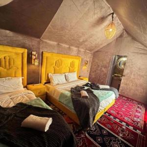 a bedroom with two beds in a tent at Eternal Luxury Camp in Merzouga