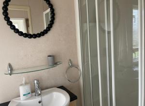 a bathroom with a sink and a mirror and a shower at Tranquil Lodge 2 Bed Sleeps 4 Free Parking in Preston +5 photos