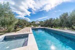 una piscina in mezzo a un cortile alberato di Holiday house Ivan with heated pool a Potirna