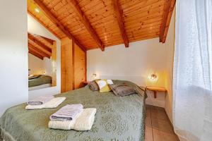 una camera da letto con un letto con due asciugamani sopra di Holiday house Ivan with heated pool a Potirna Altre 49 foto