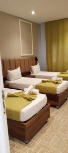 une chambre avec trois lits dans une pièce dans l'établissement Résidence touristique marcadal by Mon rêve, à Fort-de-l'Eau