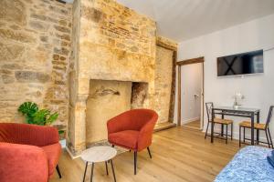 a living room with a stone wall with a fireplace at STUDIO ECUYER centre historique in Sarlat-la-Canéda