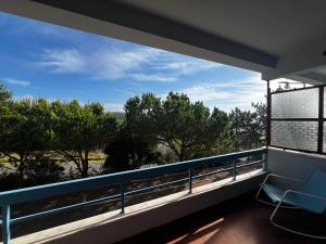 einen Balkon mit einem Stuhl und Blick auf die Bäume in der Unterkunft Casa da Areia Branca in Bolembre de Baixo
