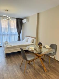a bedroom with a bed and a table and chairs at Chantrer in Burgas City