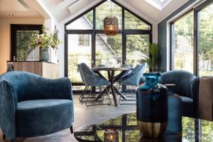 a living room with a table and chairs and windows at Résidence Lage Vuursche in Lage-Vuursche