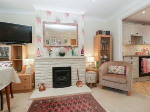 a living room with a fireplace and a chair at Evergreen in Broadway