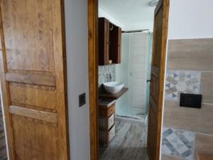 a bathroom with a wooden door and a sink at La casa di Astrid vacation home in Bussoleno +31 photos