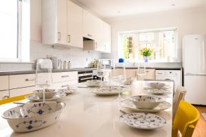 a kitchen with a table with dishes on it at The Hamptons - Entire Seafront Property with Stunning Sunsets in Herne Bay