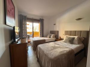 a hotel room with two beds and a television at Spacious ground floor apartment in Punta Prima +36 photos