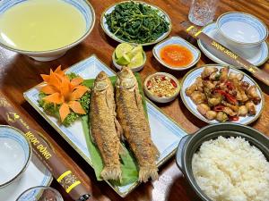 a table topped with food with fish and rice at Làng Sinh Thái Ngọc Đồng - Eco Village Retreat in Thanh Sơn