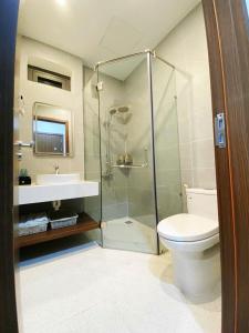 a bathroom with a shower and a toilet and a sink at Lumia Hotel in Ho Chi Minh City +13 photos