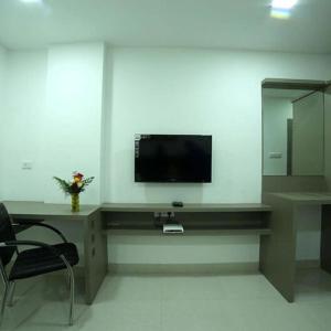 a living room with a tv on a wall at Cosy Room With Private Bath And Work Desk in Hyderabad
