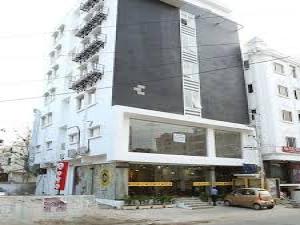 a tall building with a car parked in front of it at Cosy Room With Private Bath And Work Desk in Hyderabad