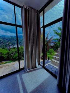 a room with a large window with a view at Reiss Villa Kandy in Kandy +12 photos
