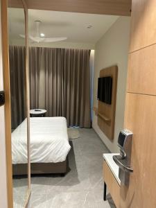 a hotel room with a bed and a tv at 7 Apple Hotel Vizag, Visakhapatnam in Dāpuri