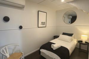 a small bedroom with a bed and a mirror at 5 Bed 5 Bath Urban Getaway Ipswich Central in Ipswich +20 photos