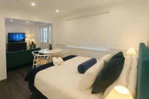 a bedroom with a large bed and a living room at 5 Bed 5 Bath Urban Getaway Ipswich Central in Ipswich +32 photos