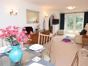 a living room with a glass table with a vase of flowers at 1 Bed in Ashley Heath 50147 in Saint Ives