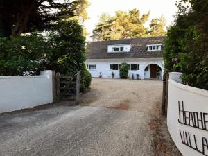 a white house with a gate and a driveway at 1 Bed in Ashley Heath 50147 in Saint Ives